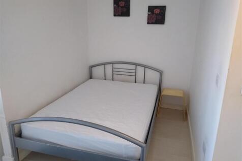 Bright bedroom with a modern double bed frame...