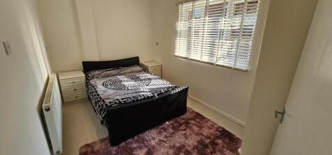 A well-lit double bedroom featuring a comfortab...