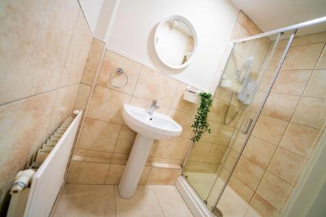 Comfortable bathroom featuring a sink, a shower...