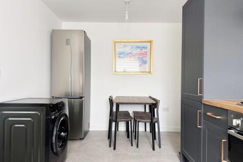 Modern kitchen with dining area and sleek units...