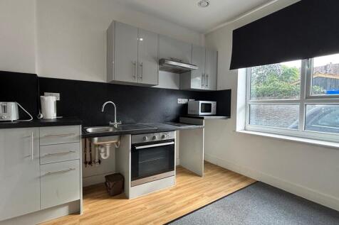 Modern kitchen with sleek grey units and window...