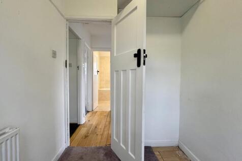 Bright, neutral hallway with crisp white walls,...