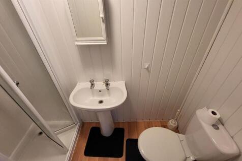 Compact, well-kept bathroom with a corner showe...