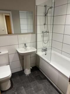 Modern tiled bathroom with a bathtub and shower...