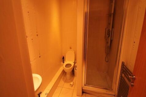 Compact and functional bathroom featuring a sho...