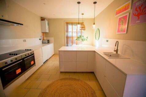 Bright modern kitchen with island and pendantin...