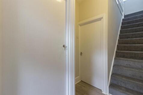 Bright hallway with modern flooring and stairs...