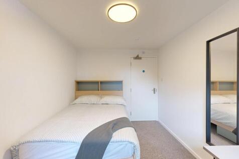 Neat, simply furnished bedroom with a comfortab...