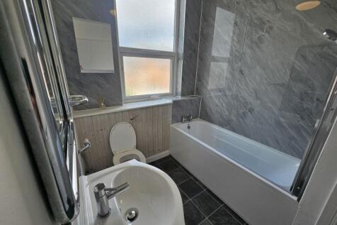 A well-maintained bathroom with a clean bathtub...
