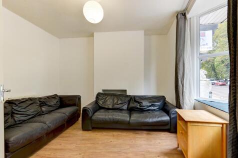 A well-lit, tidy living room featuring two larg...