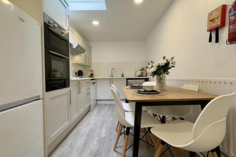 A bright and modern kitchen with ample space fo...