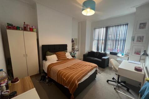 Bright, neatly arranged double bedroom with a c...