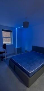 Bright, modern double bedroom with a large upho...