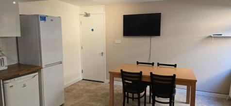 Neutral shared kitchen/dining area with a woode...
