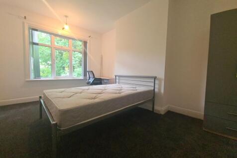 A bright and cozy single bedroom with a comfort...