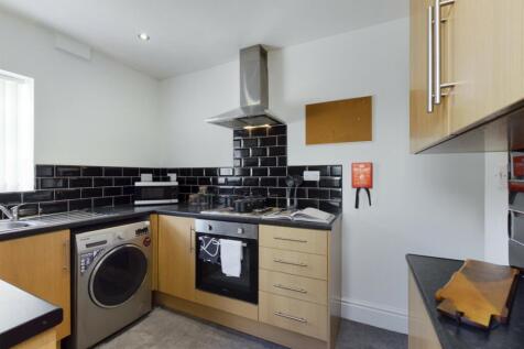 A modern kitchenette featuring sleek cabinetry ...