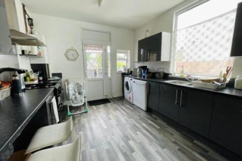 Bright, modern kitchen with ample dark cabinetr...