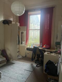 Bright, comfortably furnished bedroom with a la...