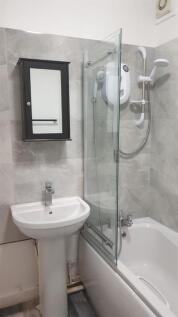 Bright, modern bathroom with a white pedestal s...