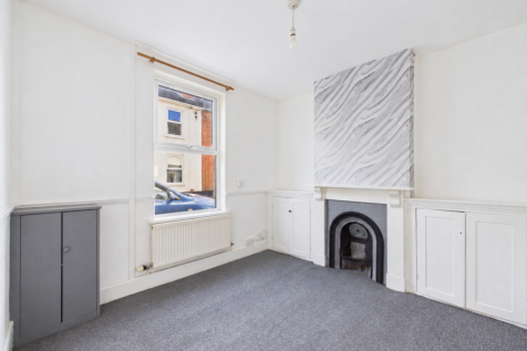 Tidied vacant room with clean carpet and cabinet
