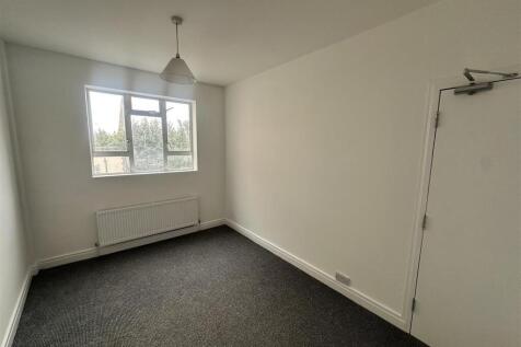 Bright simple bedroom with large window and hea...