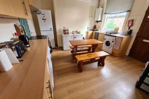 A spacious and well-lit living room featuring w...