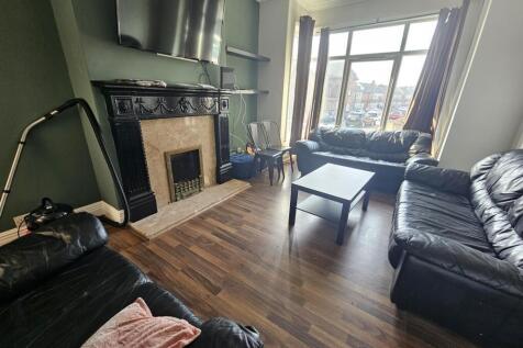 Bright living room with bay window and fireplac...