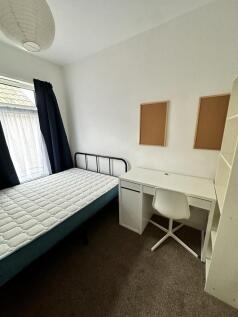 Bright bedroom with large desk and storage area...