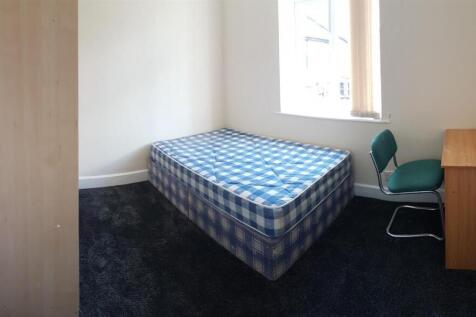 Bright, neutrally decorated bedroom with a sing...