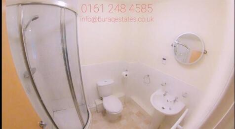 Bright, modern bathroom with a curved shower en...