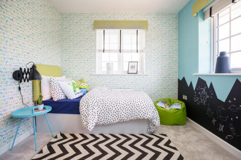 A child's bedroom features a bed with playful bedding in the foreground