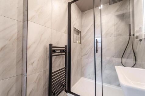 Modern marble-effect shower with sleek black tr...