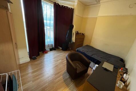 Bright single bedroom with large window and tal...