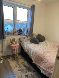 Bright, neatly styled bedroom with a large wind...