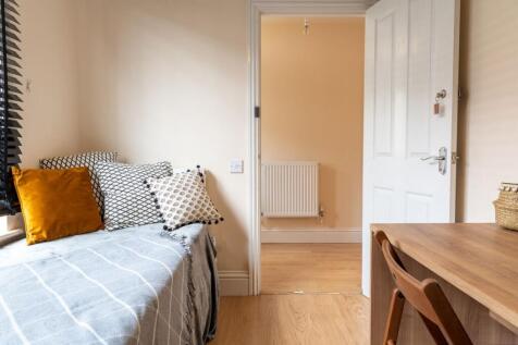 Bright, neatly styled single bedroom with a cos...