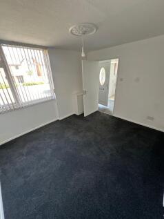 A clean and bright single bedroom featuring dar...