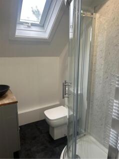 Bright, modern bathroom with a corner shower, c...