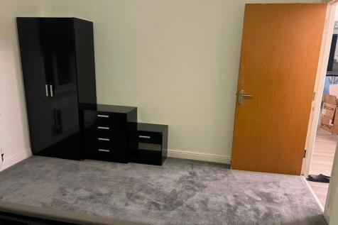 Simple furnished bedroom with neutral carpeting...