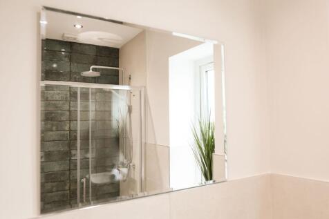 Bright modern bathroom with glass shower...