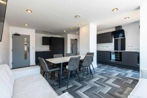 A modern kitchen and dining area with sleek bla...