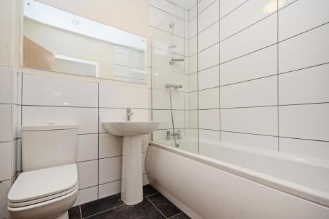 A clean and modern bathroom featuring white til...