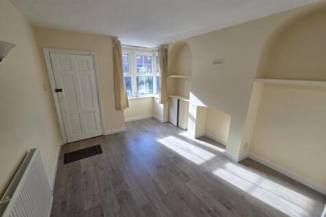 Bright living room with bay window and wood flo...