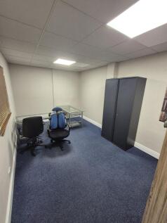 Simple, carpeted workspace with neutral walls, ...