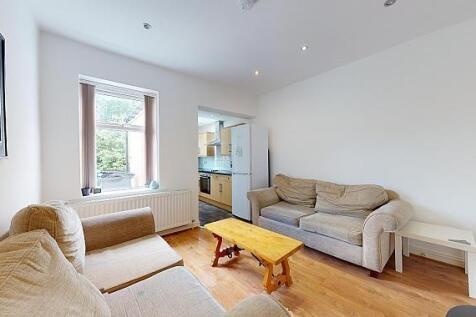 Bright living room with comfy sofas and wood fl...