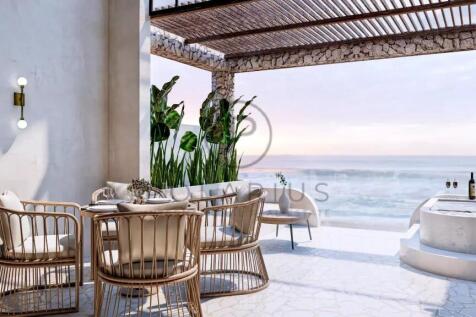 A serene outdoor patio features wicker furniture a