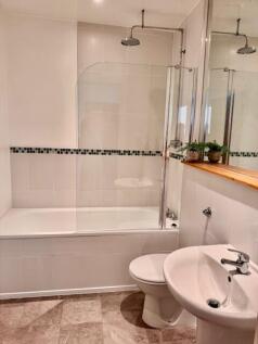 Modern bathroom with large bath and rain shower...
