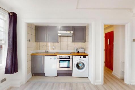 Bright compact kitchen with modern grey cabinet...