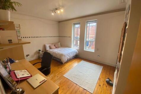 A bright and tidy bedroom featuring a spacious ...