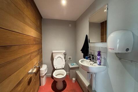 Modern WC with stylish wood panelled wall...