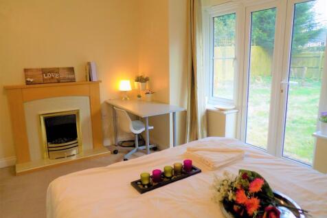 A cozy and bright master bedroom featuring a co...